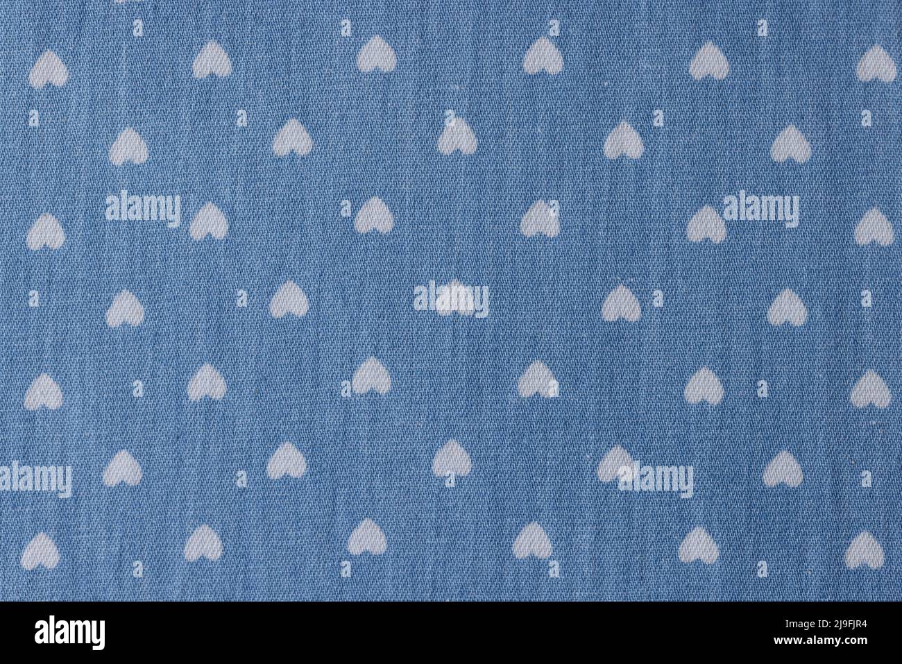 Hintergrund von weißen Zeichnungen von Herzen auf blauem Stoffhintergrund Stockfoto