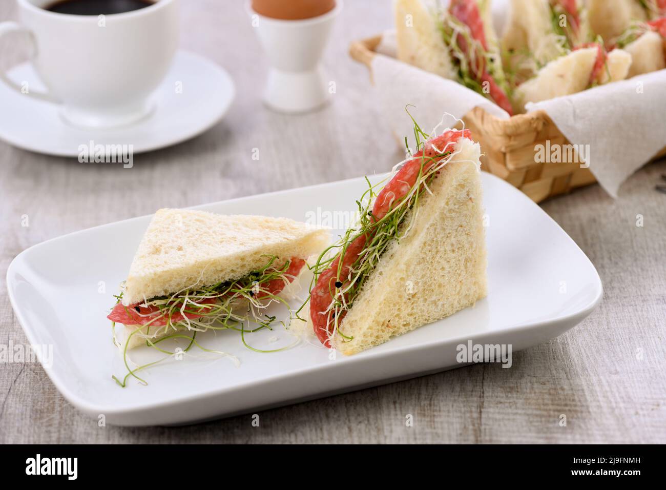 Weizen Toast Sandwich mit Frischkäse mit mikrogrünen Luzerne Sprossen und Salami. Gesunde und frische Lebensmittel. Stockfoto