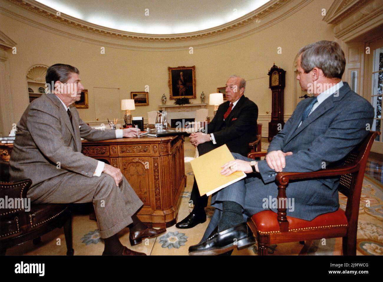 Der linke US-Präsident Ronald Reagan trifft am 14. November 1984 im Oval Office des Weißen Hauses in Washington, DC, mit dem US-Außenminister George Schultz, Mitte, und Robert McFarlane, dem Assistenten des Präsidenten für nationale Sicherheitsangelegenheiten, rechts, zusammen. Obligatorische Gutschrift: Jack Kightlinger/White House über CNP Stockfoto