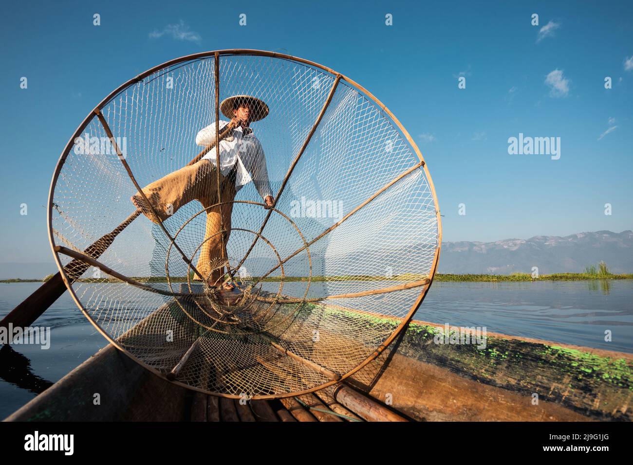 Intha Fischer Bein Rudern im traditionellen Stil auf Inle Lake, Shan Staat, Myanmar (Burma). Stockfoto