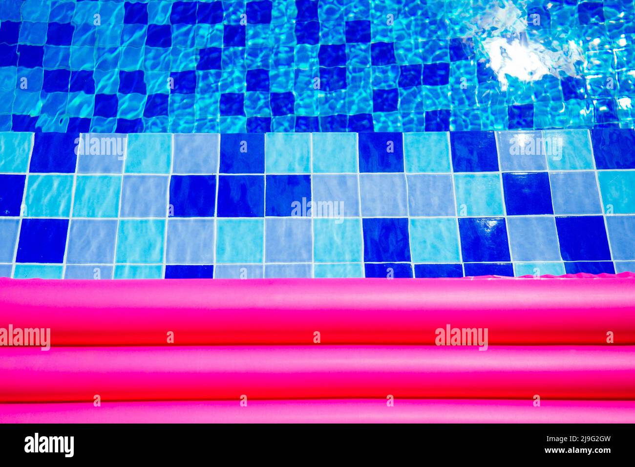 Pinke aufblasbare Matratze auf blau türkisfarbenem Wasser Swimmingpool Kopie Platz Stockfoto