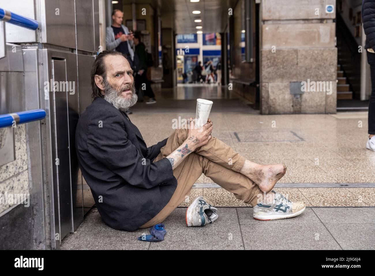 Vor der Victoria Station, London, Großbritannien, saß ein obdachloser Mann mit infiziertem Fuß und bettelte um Geld Stockfoto