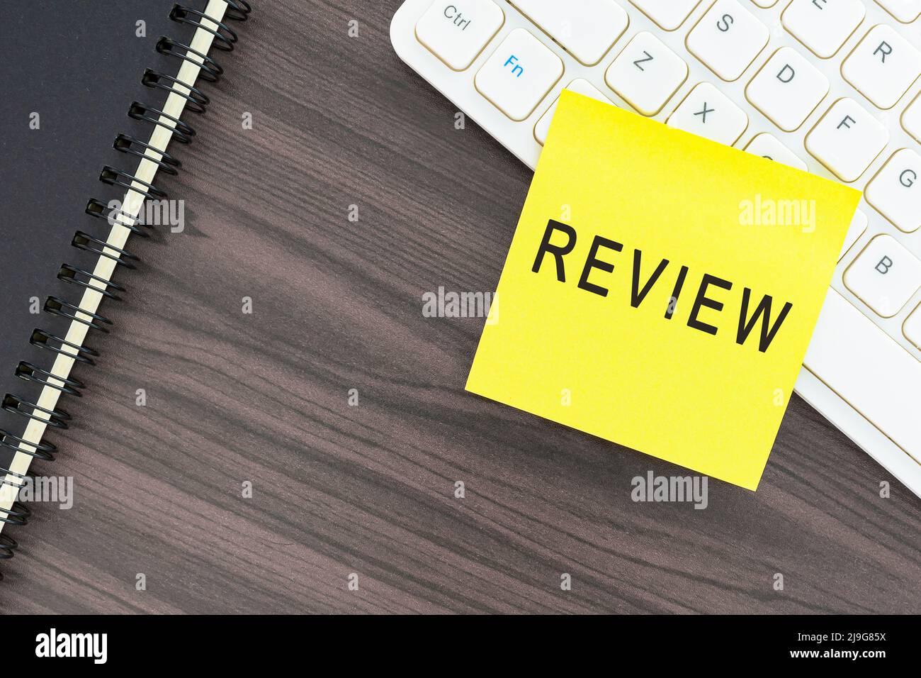 Besprechen Sie das Wort auf dem Klebehinweis auf der weißen Tastatur auf dem Holztisch. Geschäftskonzept. Stockfoto