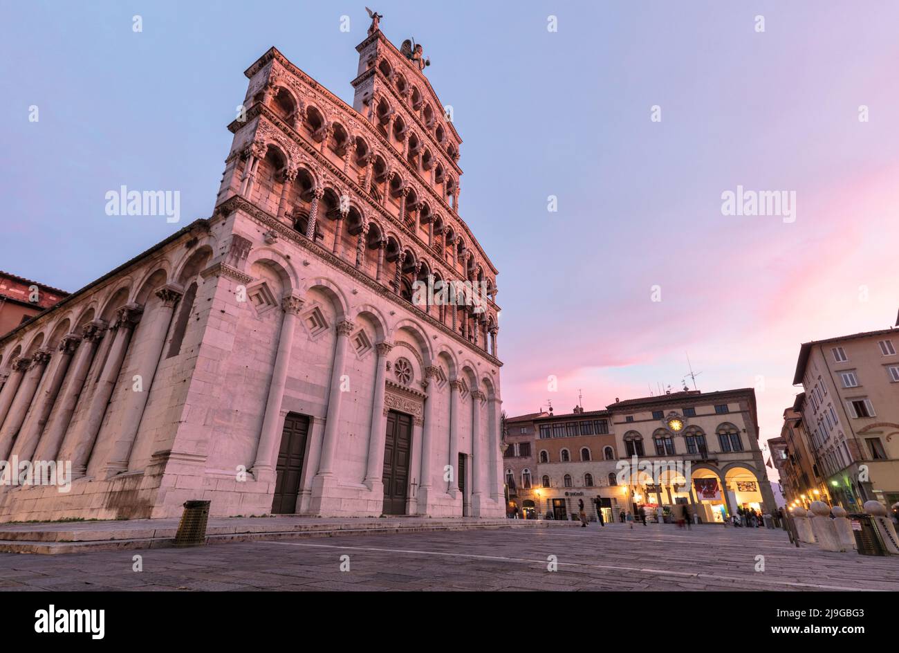 Dämmerung oder Einbruch der Nacht auf der Chiesa di San Michele im Foro auf der Piazza San Michele, Lucca. Eine Kirche aus dem 11. Jahrhundert im romanischen und späten gotischen Stil Stockfoto