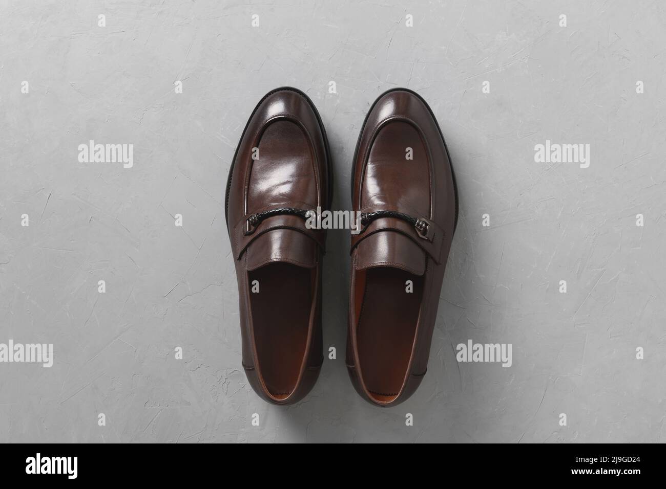Klassische männliche braune Lederschuhe isoliert auf grauem Beton Hintergrund. Draufsicht. Flach liegend. Stockfoto