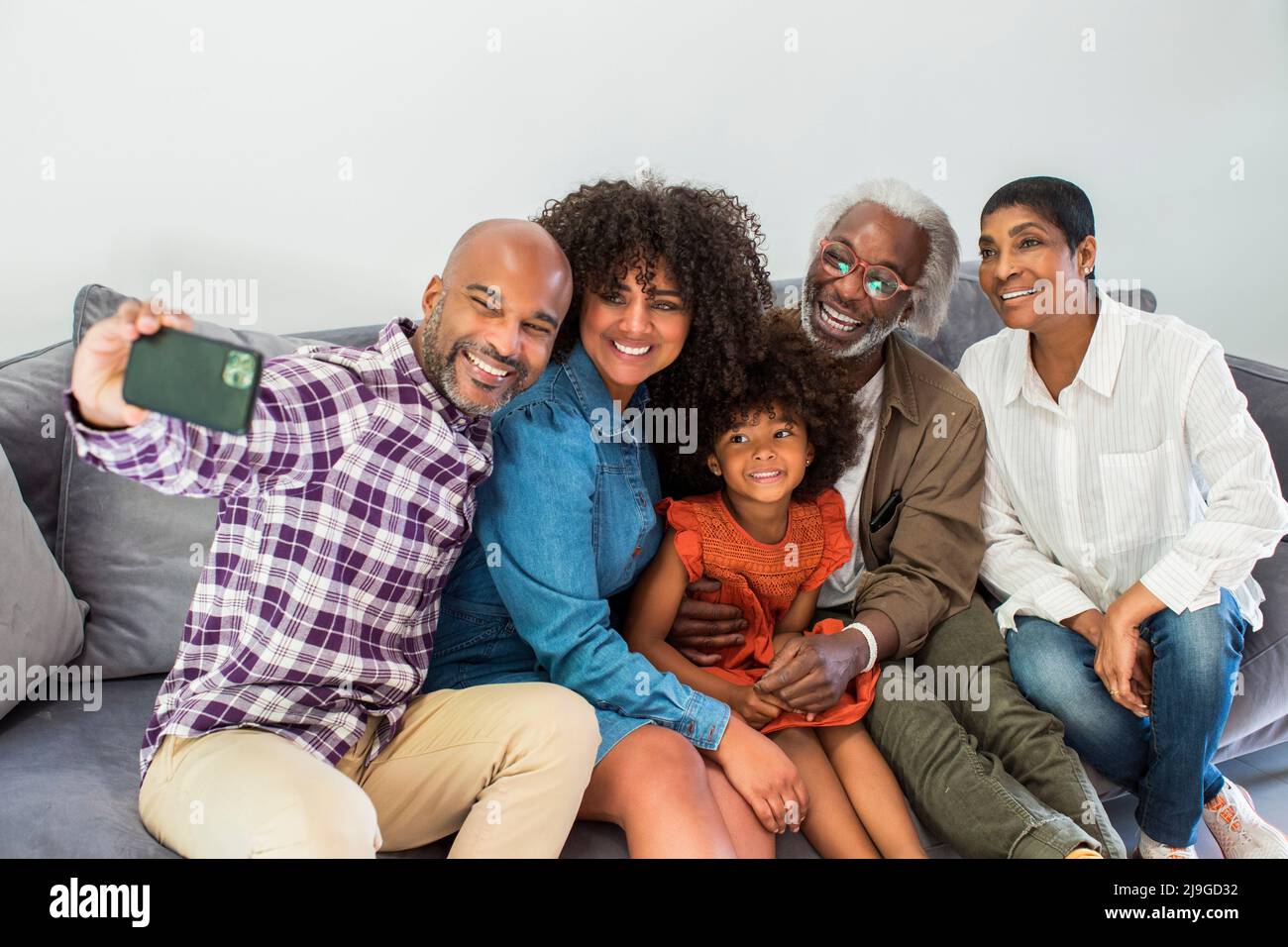 Glückliche Familie mit mehreren Generationen, die ein Selfie im Wohnzimmer macht Stockfoto