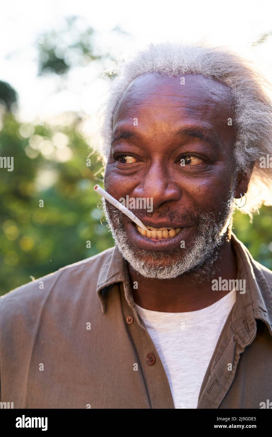 Nahaufnahme eines älteren Mannes, der eine Zigarette im Mund hält Stockfoto