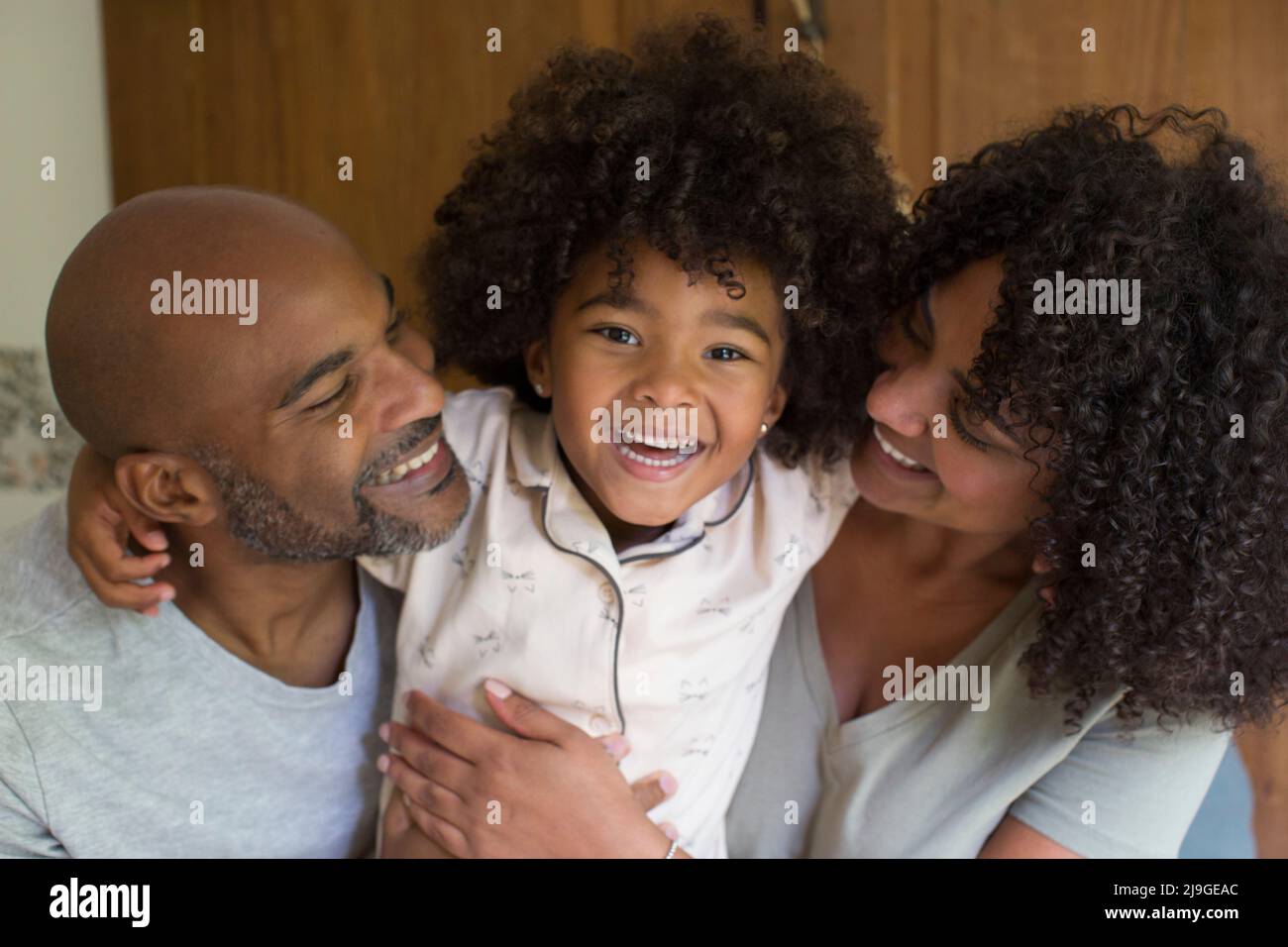 Portrait von glücklichen Eltern mit Tochter im Schlafzimmer Stockfoto