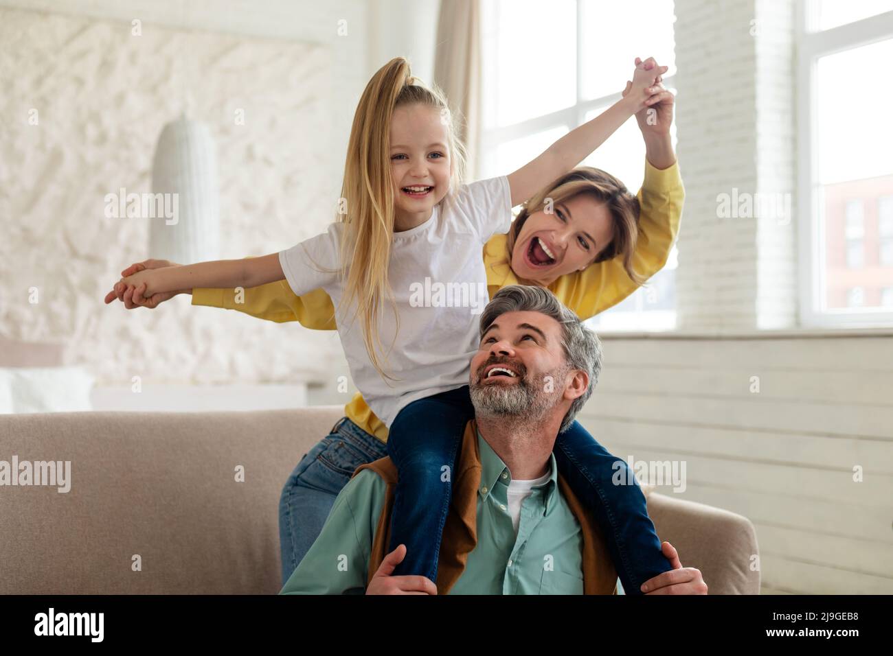 Fröhliche Eltern Und Tochter Mit Spaß Bonding Spielen Zu Hause Stockfoto