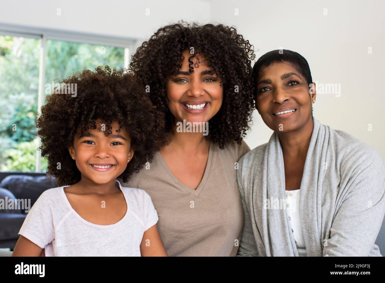 Glückliche Familie, die in mehreren Generationen im Wohnzimmer sitzt Stockfoto