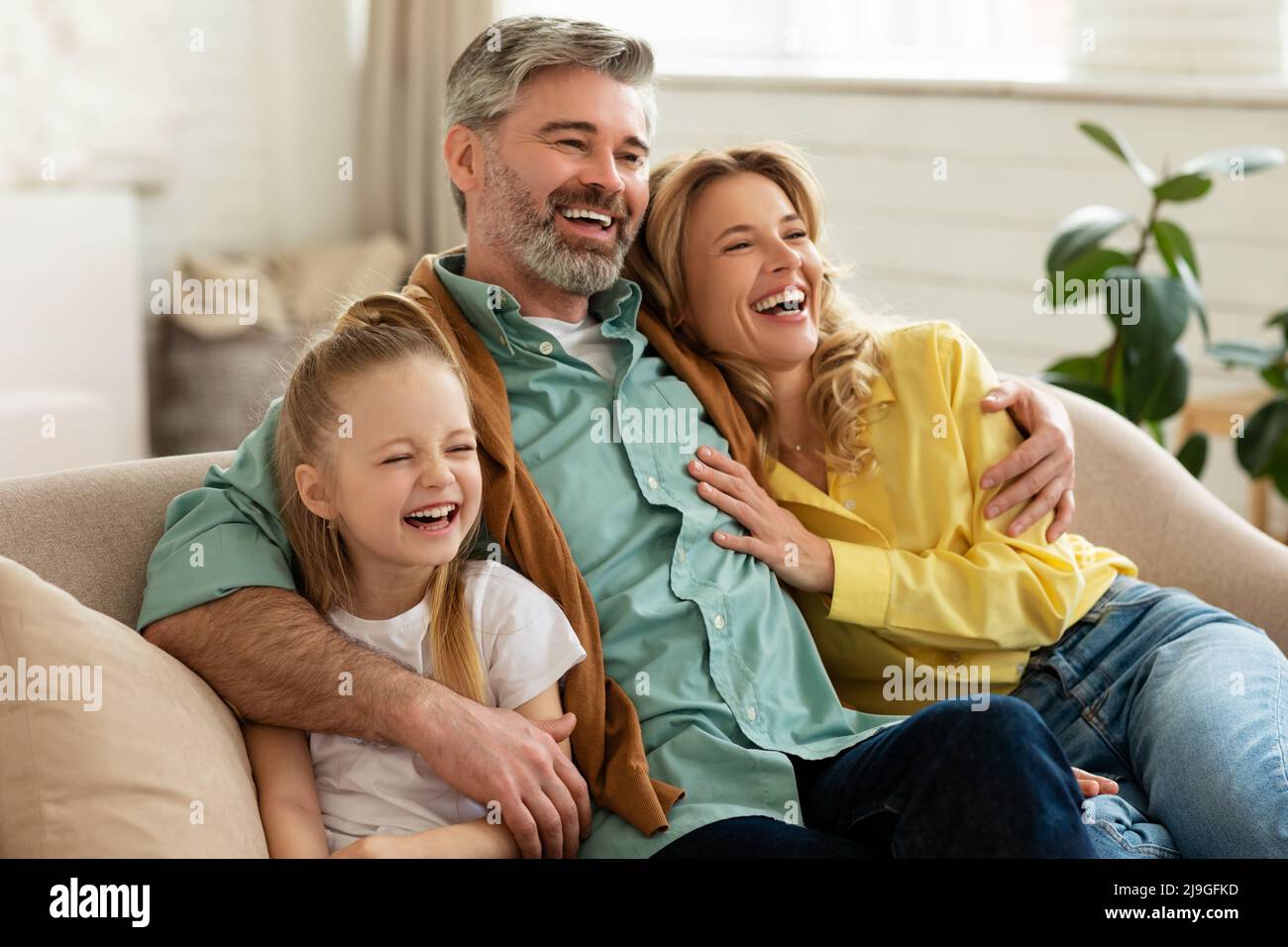 Eltern Mittleren Alters Und Tochter Umarmen Sitzen Auf Der Couch Drinnen Stockfoto