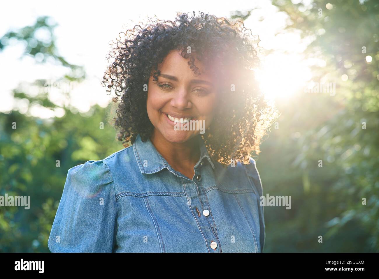 Nahaufnahme einer lächelnden Frau, die im Garten steht Stockfoto