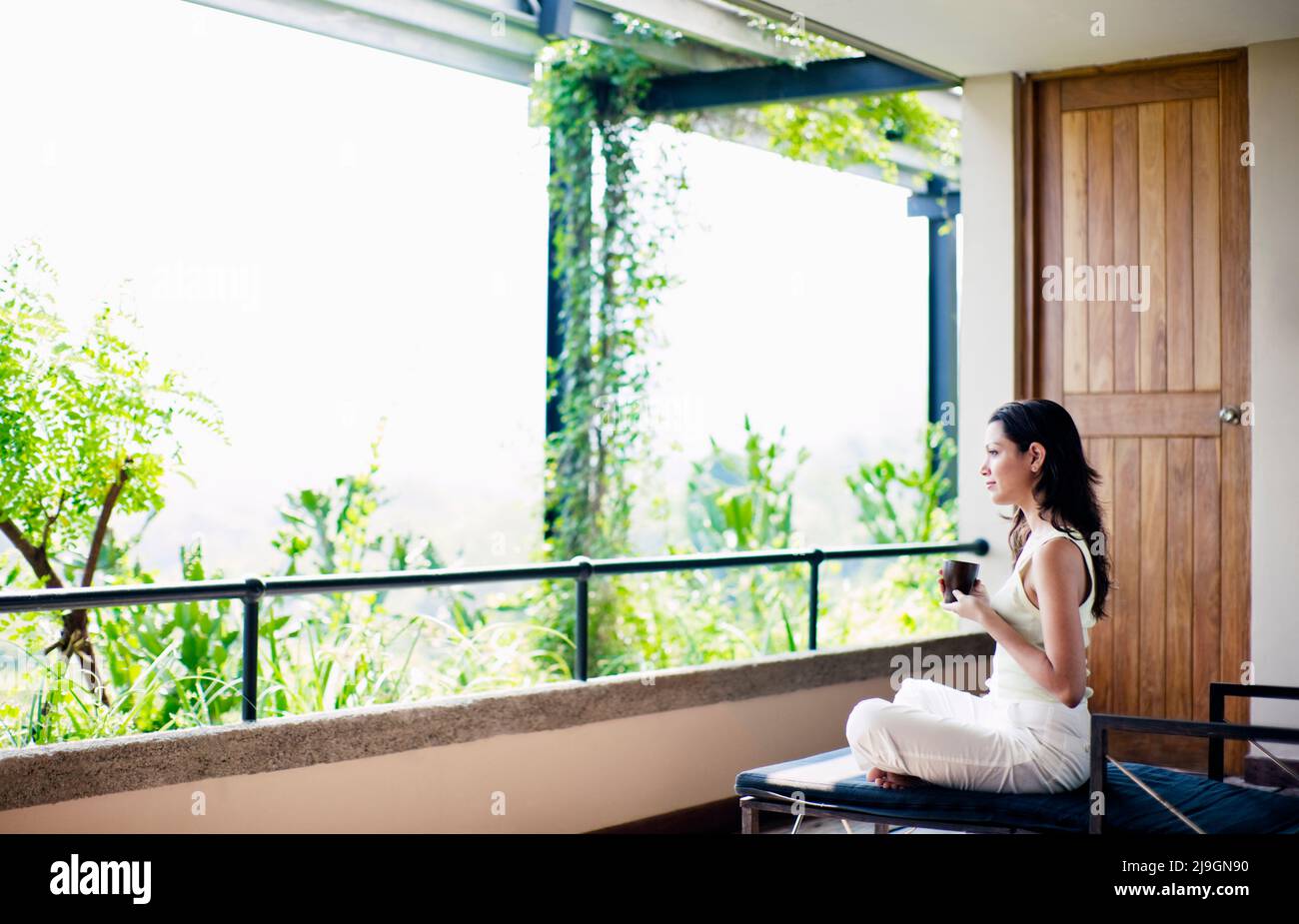 Frau trinkt Tee im Six Senses Spa, Heritance Kandalama Hotel, Dambulla, Sri Lanka. Eine Frau trinkt Kräutertee in der Six Senses Spa Entspannungslounge. Stockfoto