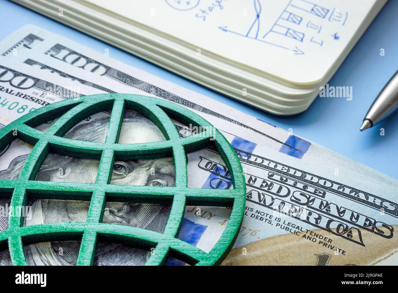 Geld und grüner Globus als Symbol für die Investition in die Umweltinvestition. Stockfoto