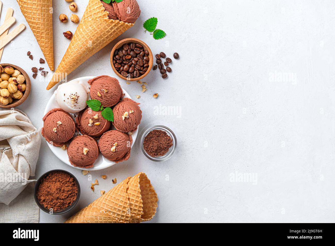 Kugeln aus Schokolade und Speiseeis auf grauem Hintergrund. Stockfoto