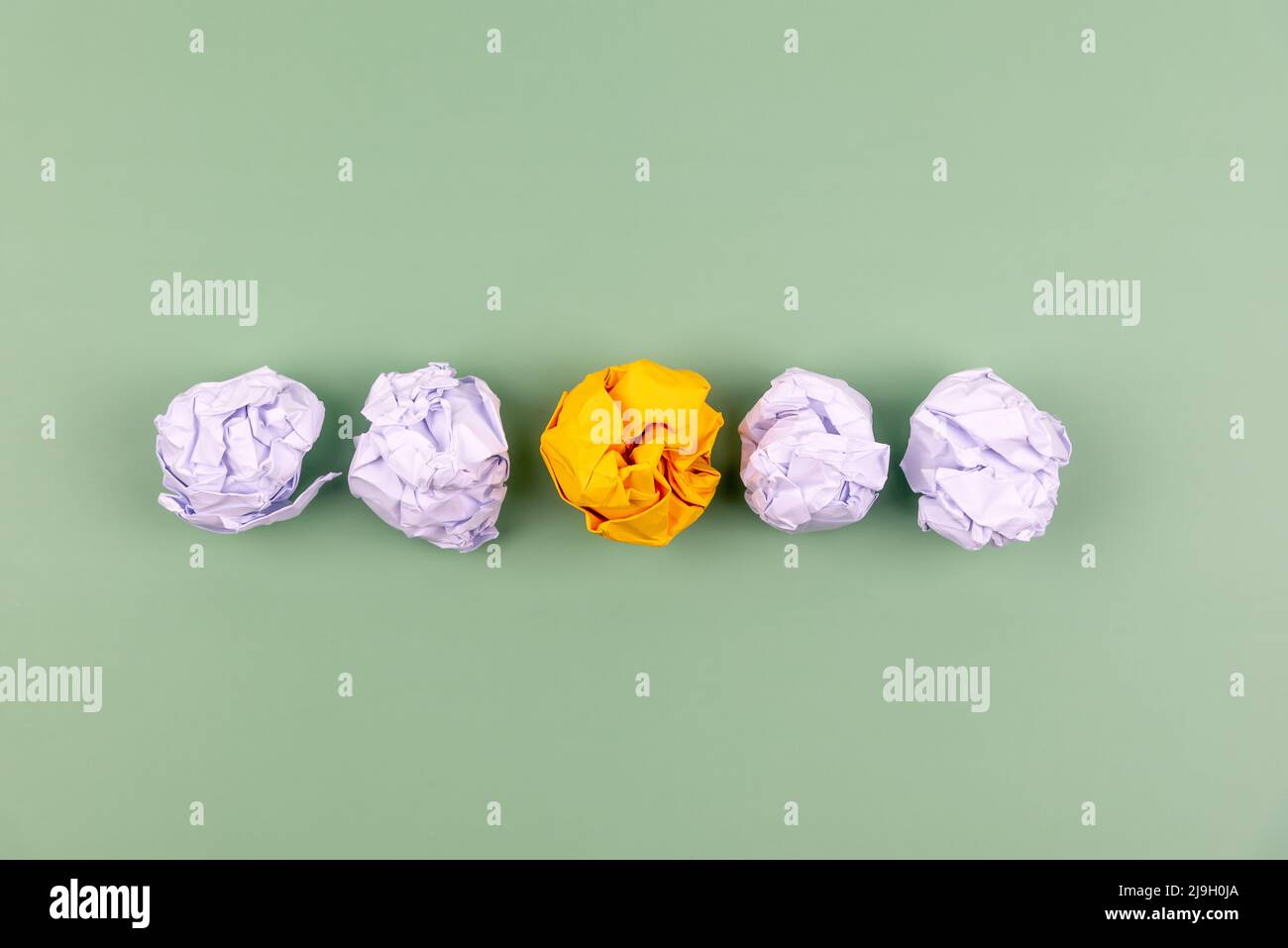 Zerknitterte Papierkugel auf grünem Hintergrund Stockfoto