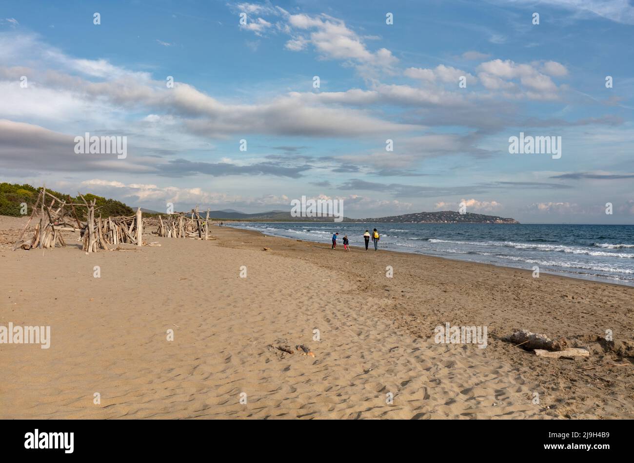 Menschen laufen am Feniglia Beach auf dem südlichen Tombolo, das das Festland mit der Monte Argentario Promontory, Orbetello, Toskana verbindet Stockfoto