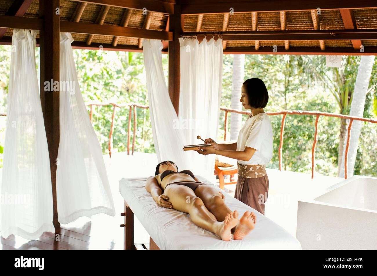 Junge asiatische Frau, die im Kayumanis Spa, Kayumanis Ubud, Bali, Indonesien, Körperpeeling erhält. Stockfoto