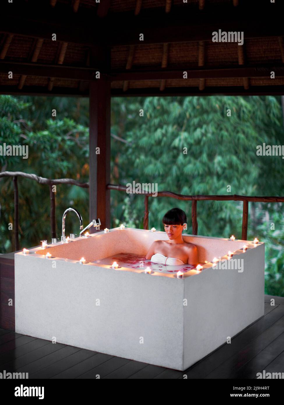 Frau in einem Milchbad bei Kerzenschein, Kayumanis Spa, Kayumanis Ubud, Bali, Indonesien. Stockfoto
