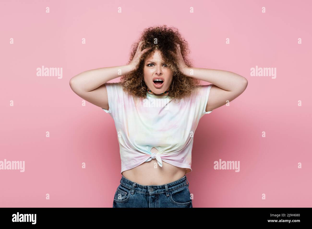 Gestresste Frau im T-Shirt schreiend auf rosa Hintergrund Stockfoto