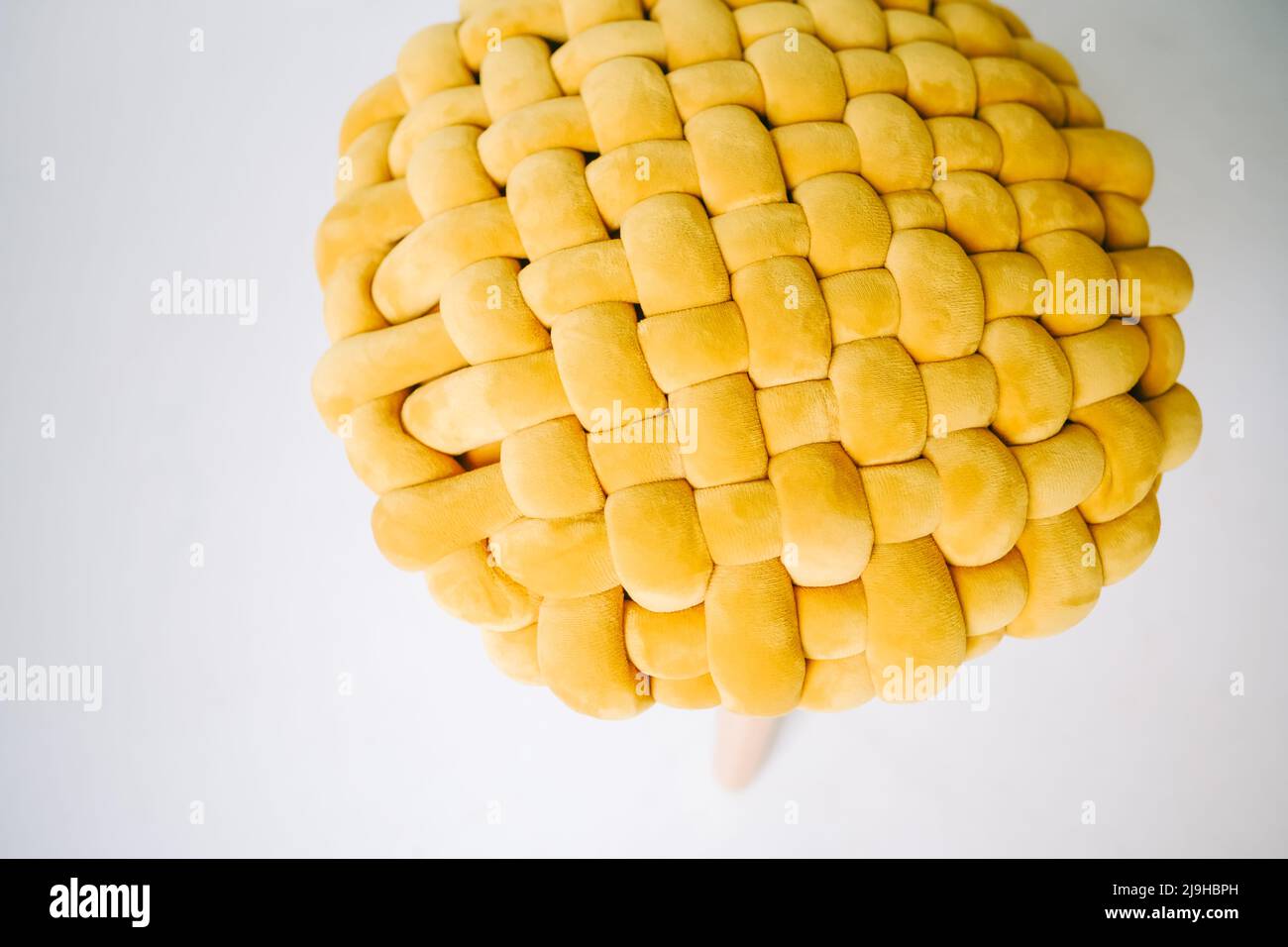 Gelber gepolsterter Stuhl auf weißem Boden, Nahaufnahme. Stockfoto