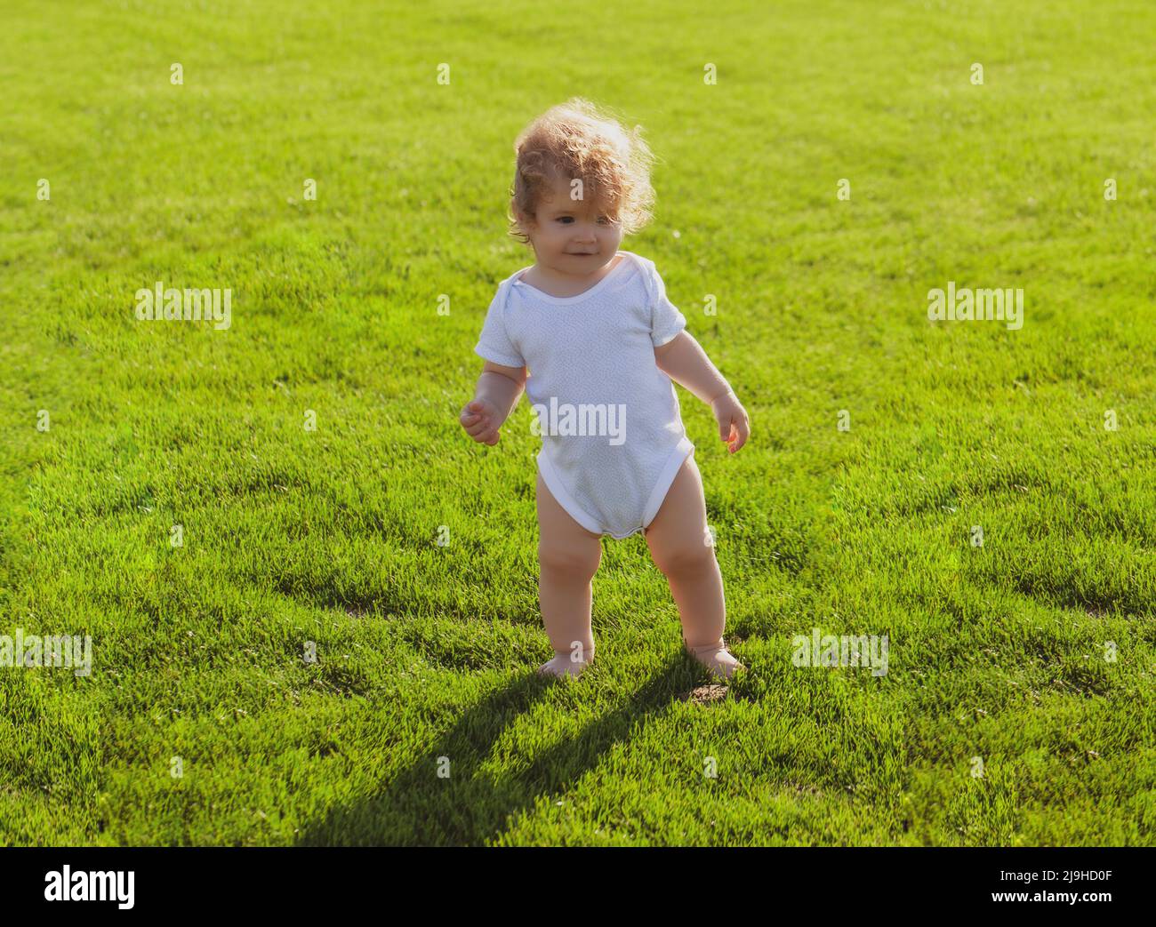 Baby Junge Kleinkind zu Fuß in einem Park am hellen Frühlingstag. Entwicklung von Kindern. Stockfoto