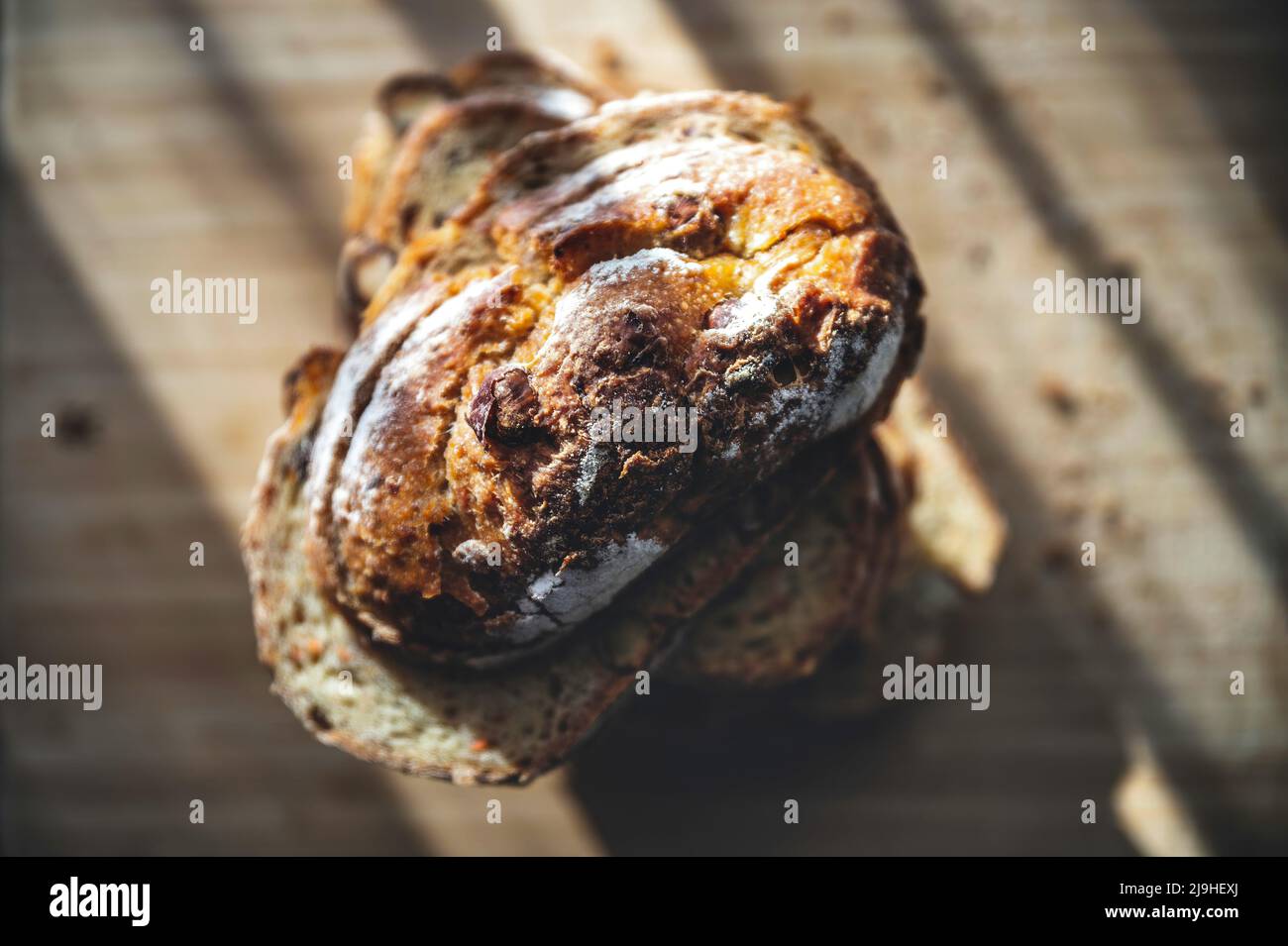 Sonnenlicht fällt auf frisch gebackene Brotscheiben auf dem Tisch Stockfoto