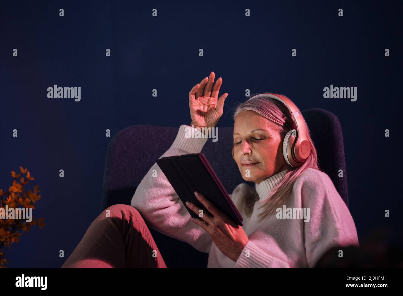 Ältere Frau, die zu Hause Wireless-Technologien verwendet Stockfoto