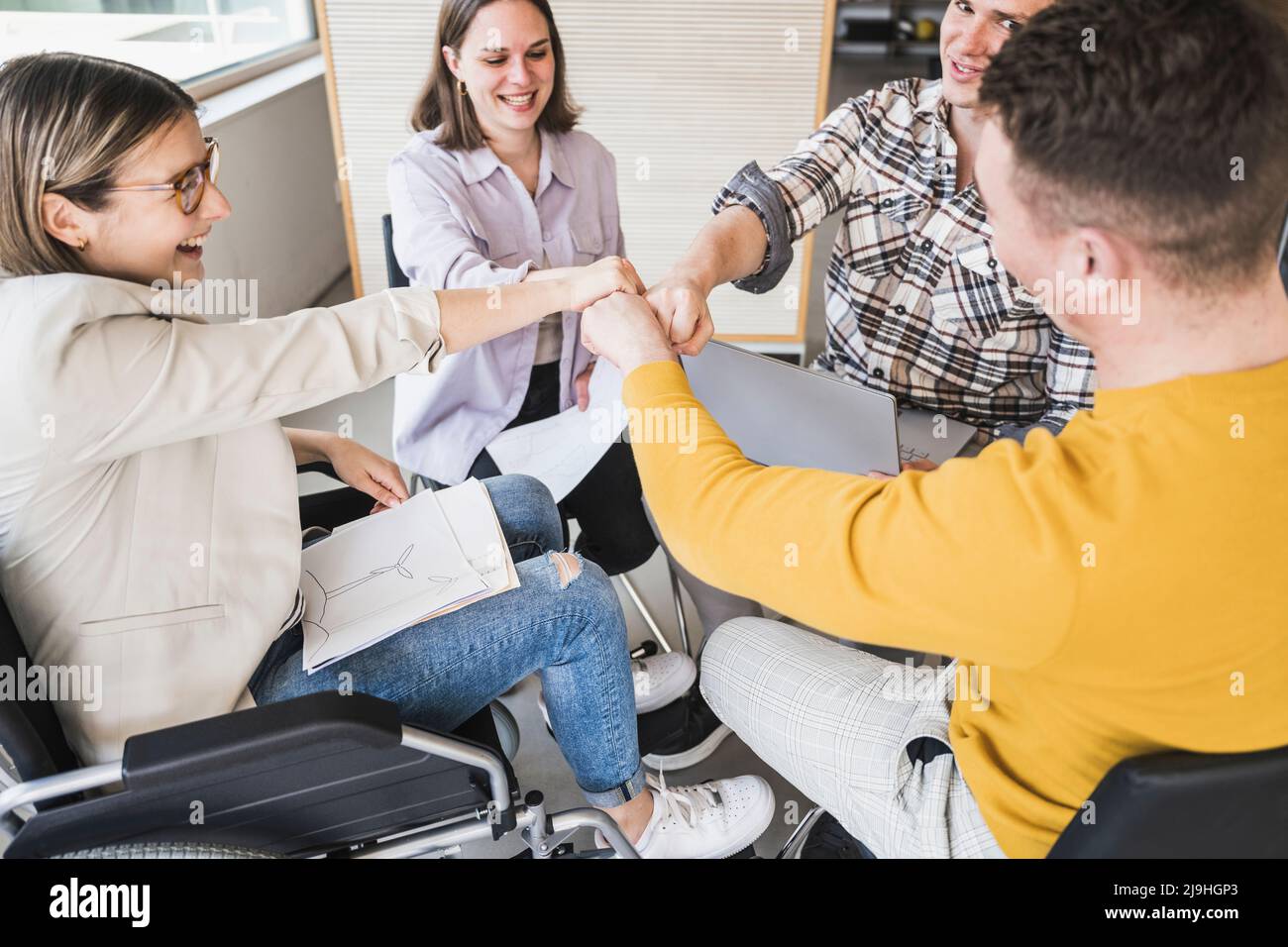 Das Geschäftsteam rührt sich im Büro mit den Fäusten Stockfoto