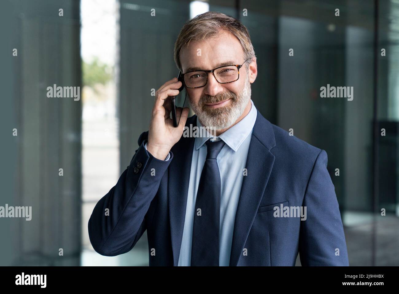 Geschäftsmann im Anzug im Gespräch auf dem Smartphone Stockfoto