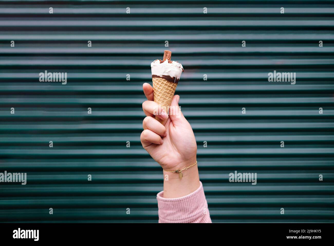Hand einer Frau, die Eiscreme vor dem Verschluss hält Stockfoto