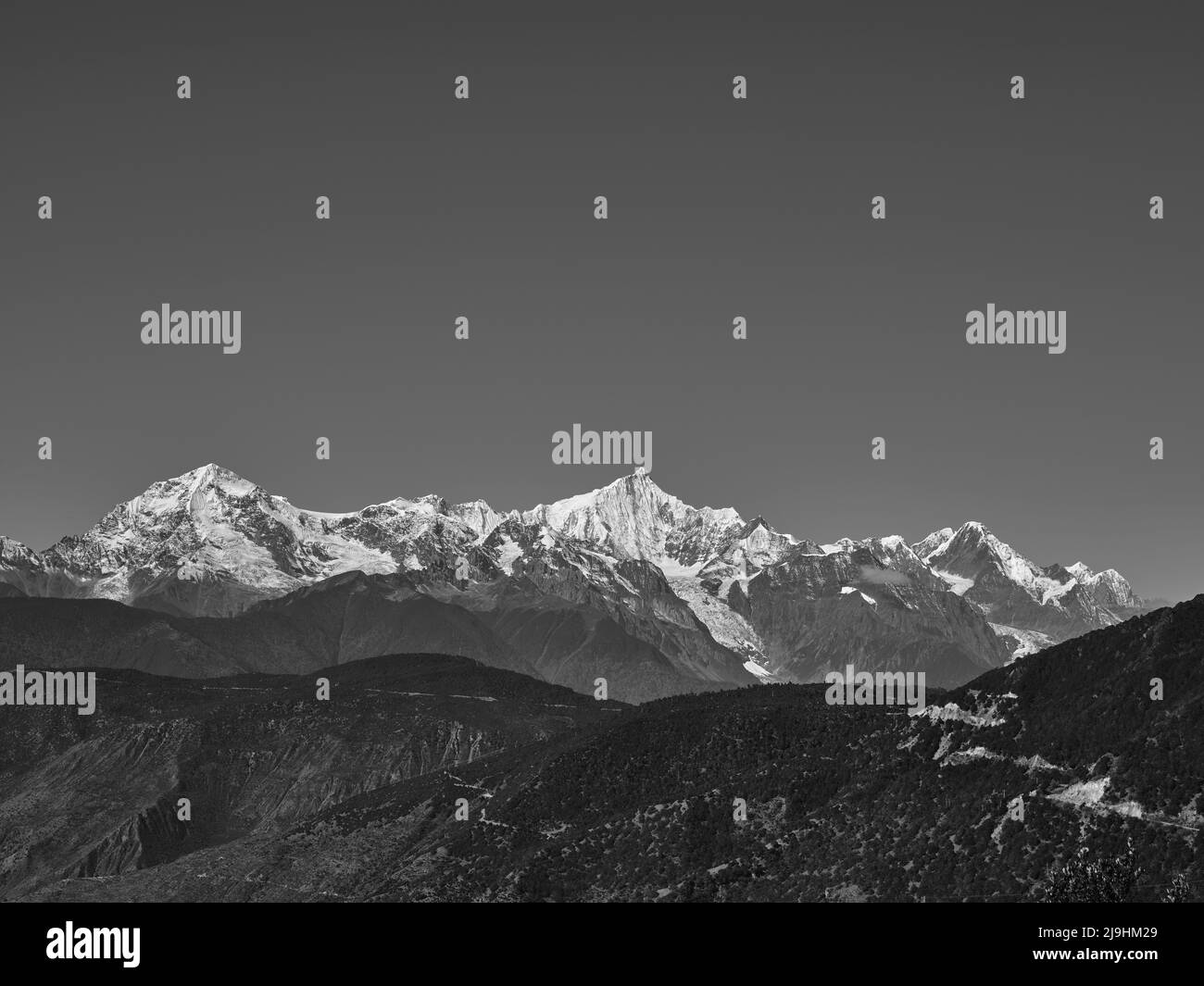 Hügelige Schneeberge der meili Range in Schwarz und Weiß Stockfoto