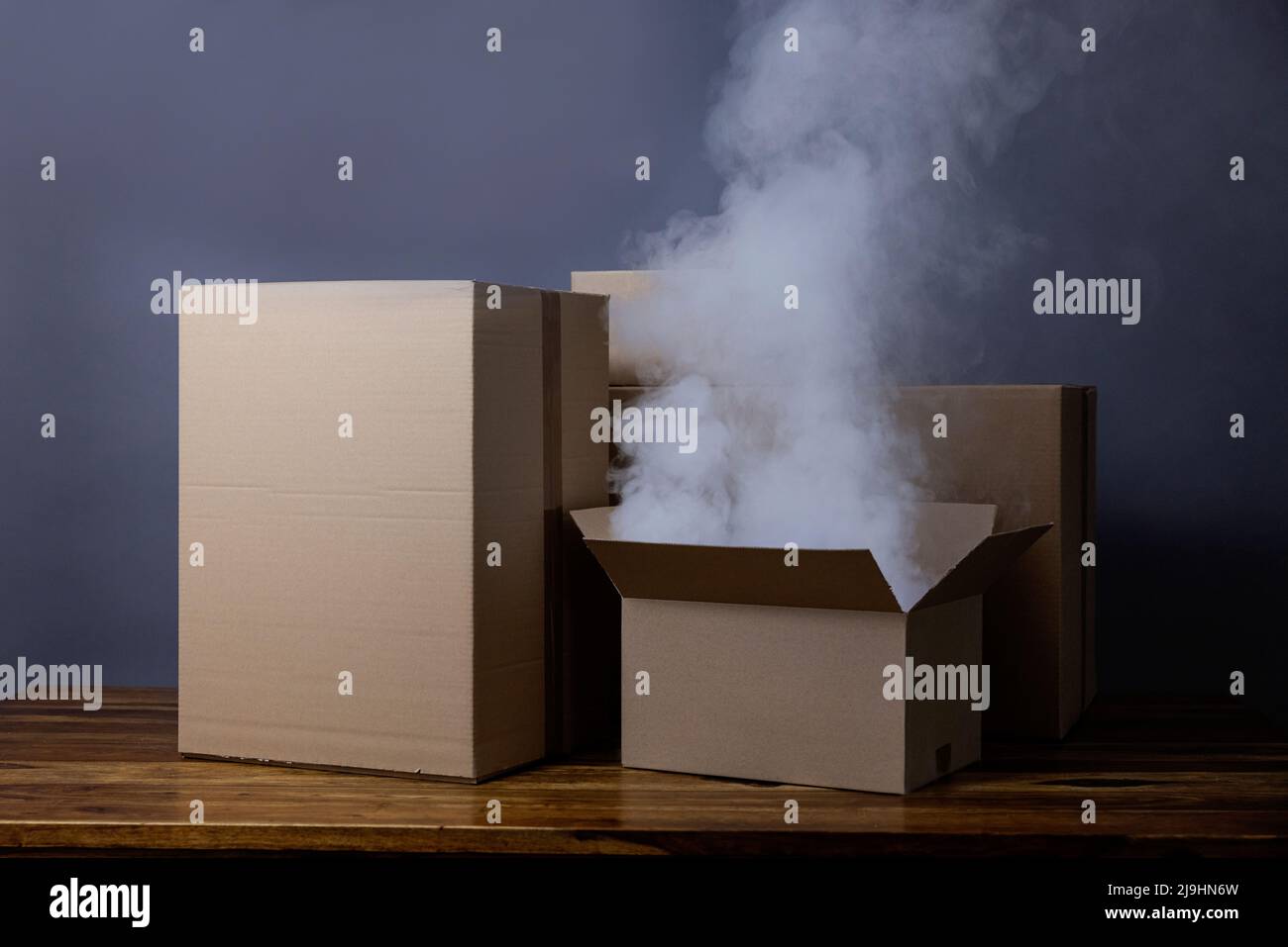 Studioaufnahme des Rauchens, der aus dem offenen Karton aufsteigt Stockfoto