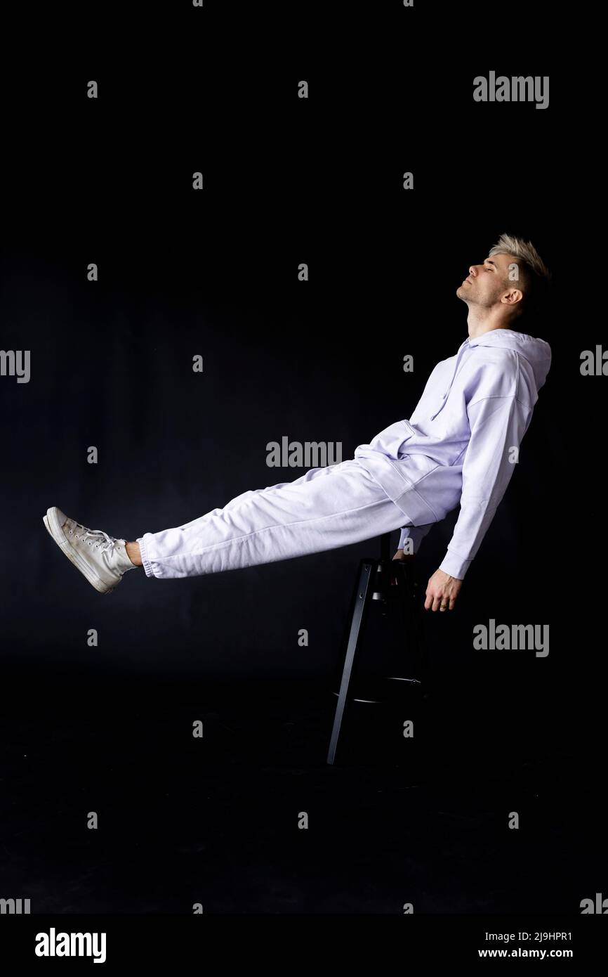 Junger Mann mit geschlossenen Augen schweben vor schwarzem Hintergrund Stockfoto