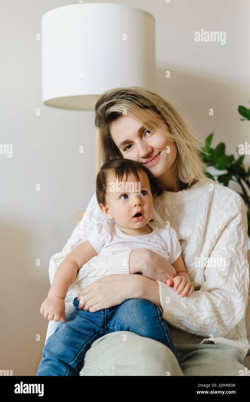 Lächelnde Mutter mit einem Jungen, der zu Hause sitzt Stockfoto
