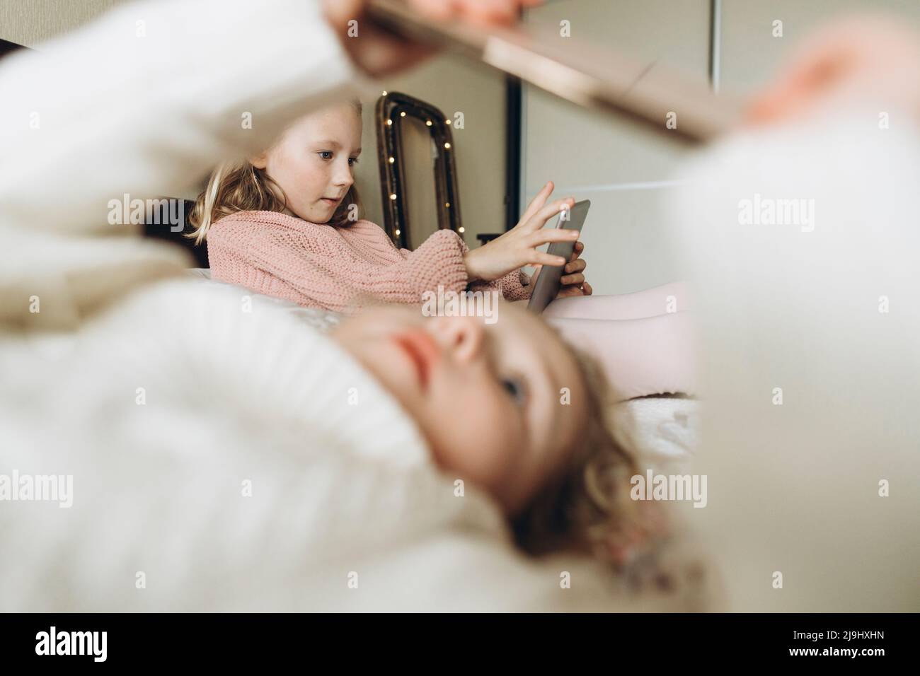 Mädchen, die zu Hause im Schlafzimmer Smartphones benutzen Stockfoto