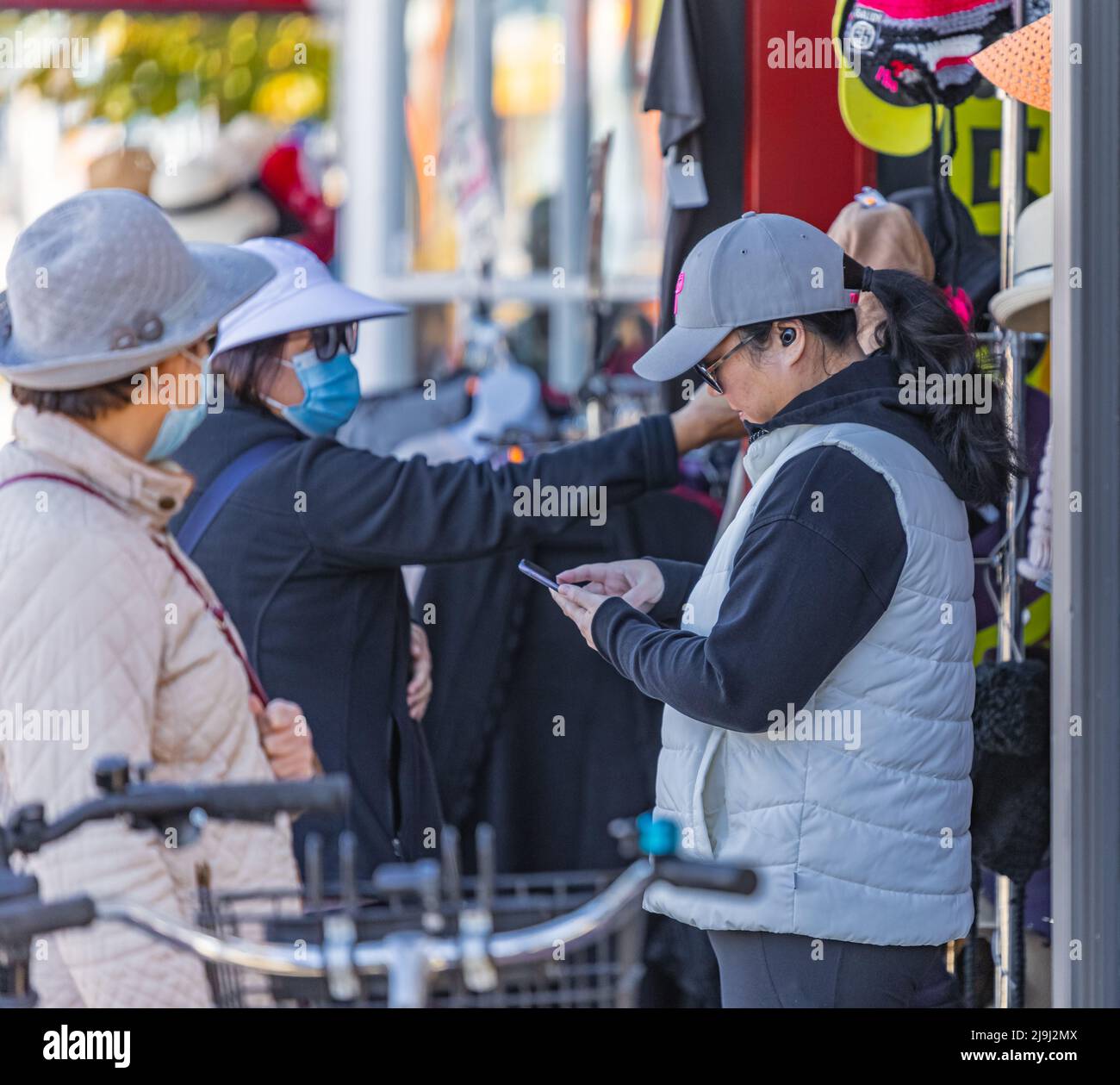 Frauen stöbern auf einem Straßenmarkt in einer Kleiderstange. Kunden suchen und wählen Kleidung, Geschenke auf den Straßenmärkten. Reisefoto, Straßenansicht Stockfoto