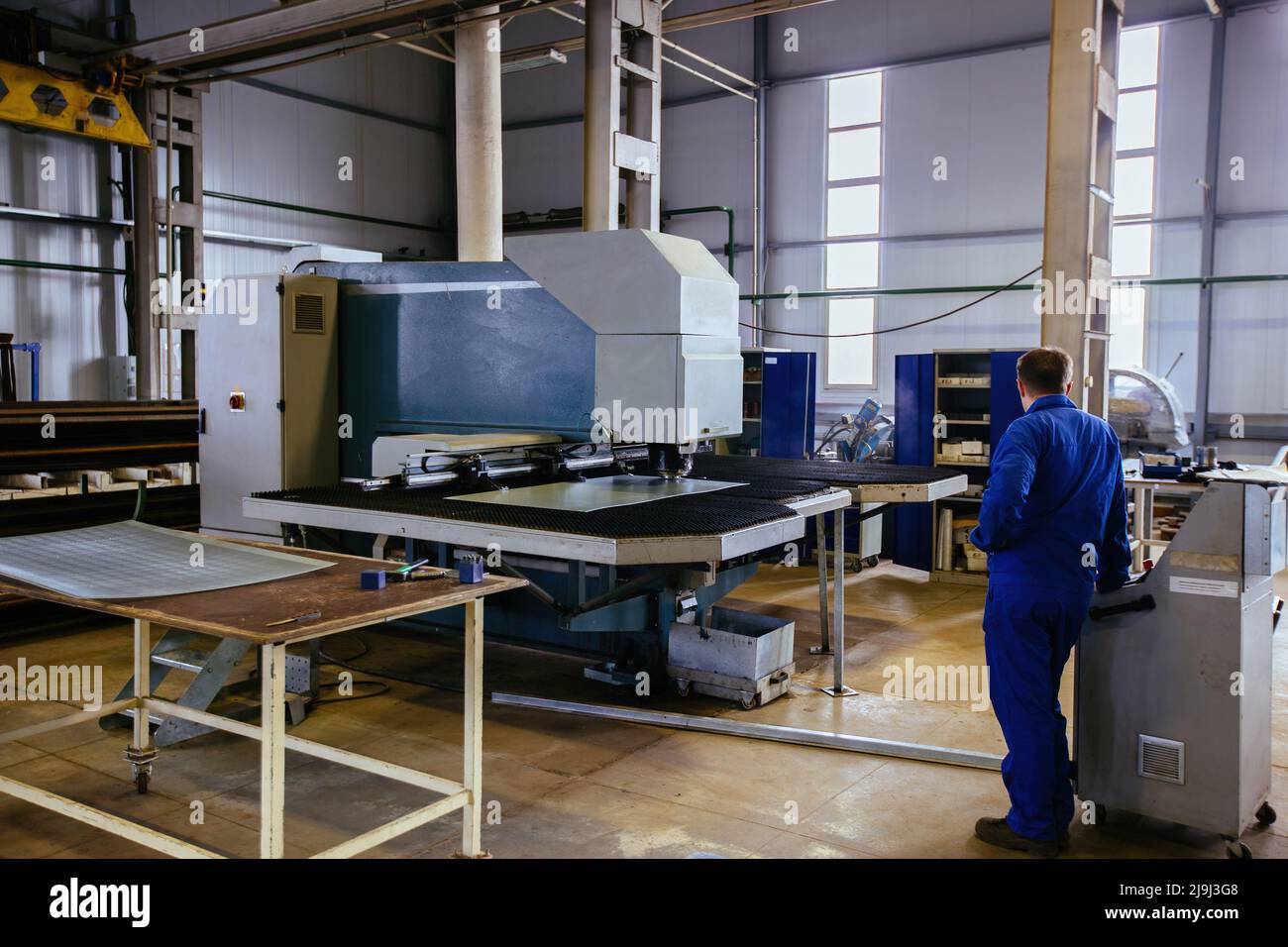 CNC Stanz- und Perforationsmaschine und perforiertes Stahlblech. Stockfoto