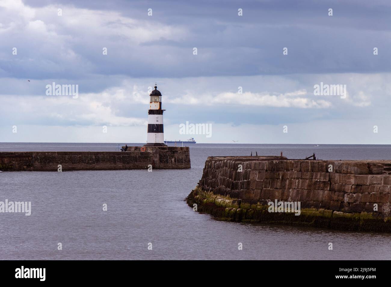 Ikonischer gestreifter Leuchtturm von Seaham am Pier mit Meeresmauern Stockfoto