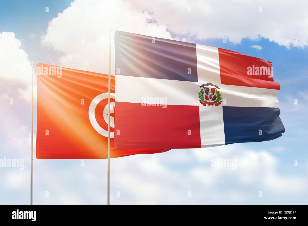 Sonniger blauer Himmel und Flaggen der dominikanischen republik und tunesiens Stockfoto