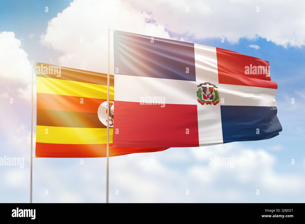 Sonniger blauer Himmel und Flaggen der dominikanischen republik und ugandas Stockfoto