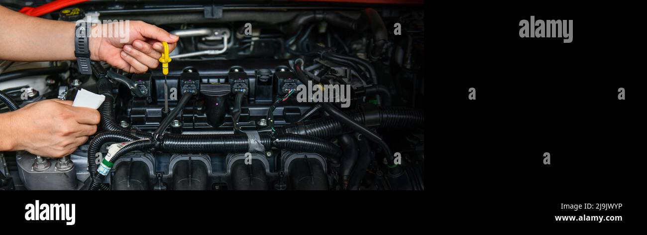 Ein professioneller Mechaniker hält den Ölmessstab, um den Ölstand im Automotor zu überprüfen, Platz zu kopieren Stockfoto