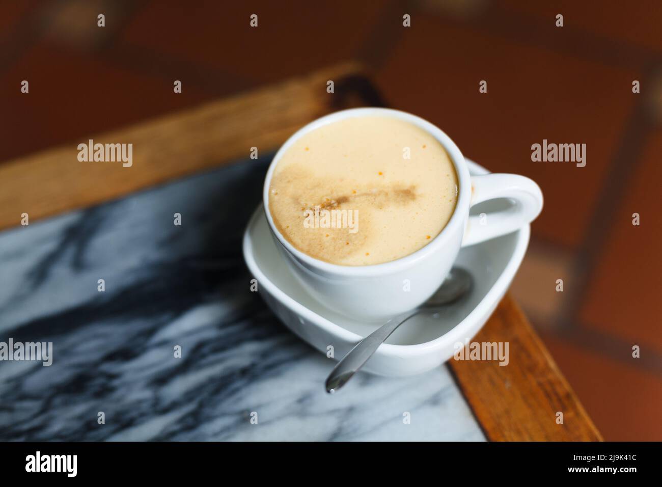 Draufsicht eine Tasse Giang Eierkaffee auf Holz Hintergrund. Vietnamesischer Kaffee in Ha Noi, Vietnam. Eier werden mit Kaffee, Heißgetränk oder mit Eis geschlagen Stockfoto