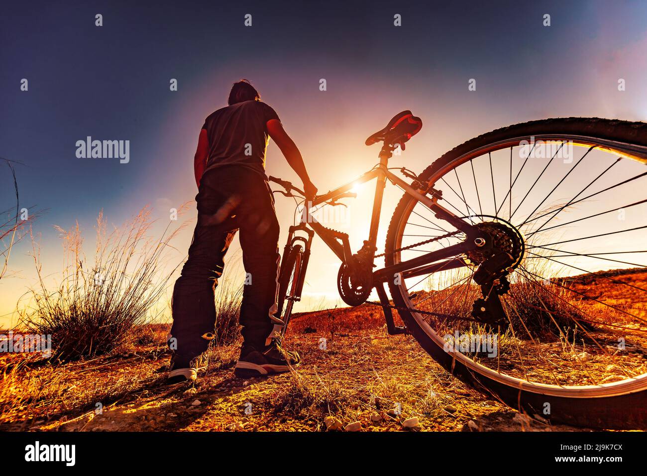 Biker- und Sonnenuntergangslandschaft.Freizeit im Freien mit dem Mountainbike. Extremsport und Erholung. Stockfoto