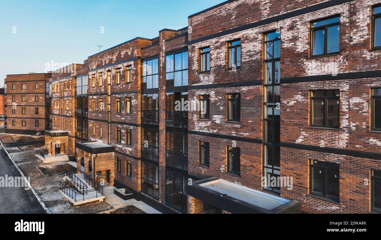 Ein neues Ziegelhaus, das mit weißer Aufblühung befleckt ist, ein Kristallin aus Salz, das sich aufgrund des Wasseranlasses in den Ziegeln gebildet hat. Konstruktionsfehler Stockfoto