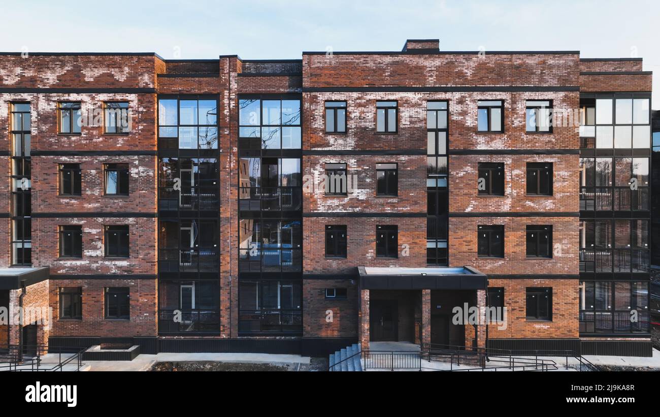 Ein neues Ziegelhaus, das mit weißer Aufblühung befleckt ist, ein Kristallin aus Salz, das sich aufgrund des Wasseranlasses in den Ziegeln gebildet hat. Konstruktionsfehler Stockfoto