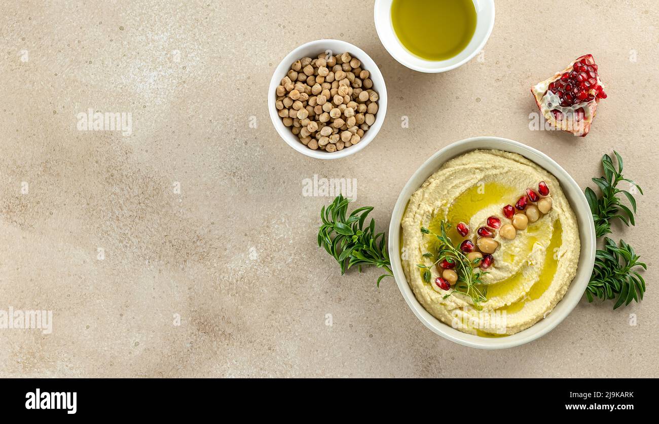 Hummus, pürierte Kichererbsen mit Granatapfel, Limette, Gewürzen, Olivenöl und Kräutern Stockfoto