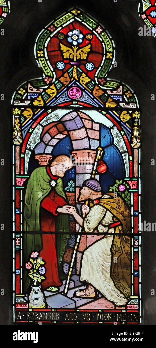 Ein Buntglasfenster von Frederick Preedy, das Corporal Acts of Mercy, St Peter and St Paul's Church, King's Sutton, Northamptonshire, zeigt Stockfoto