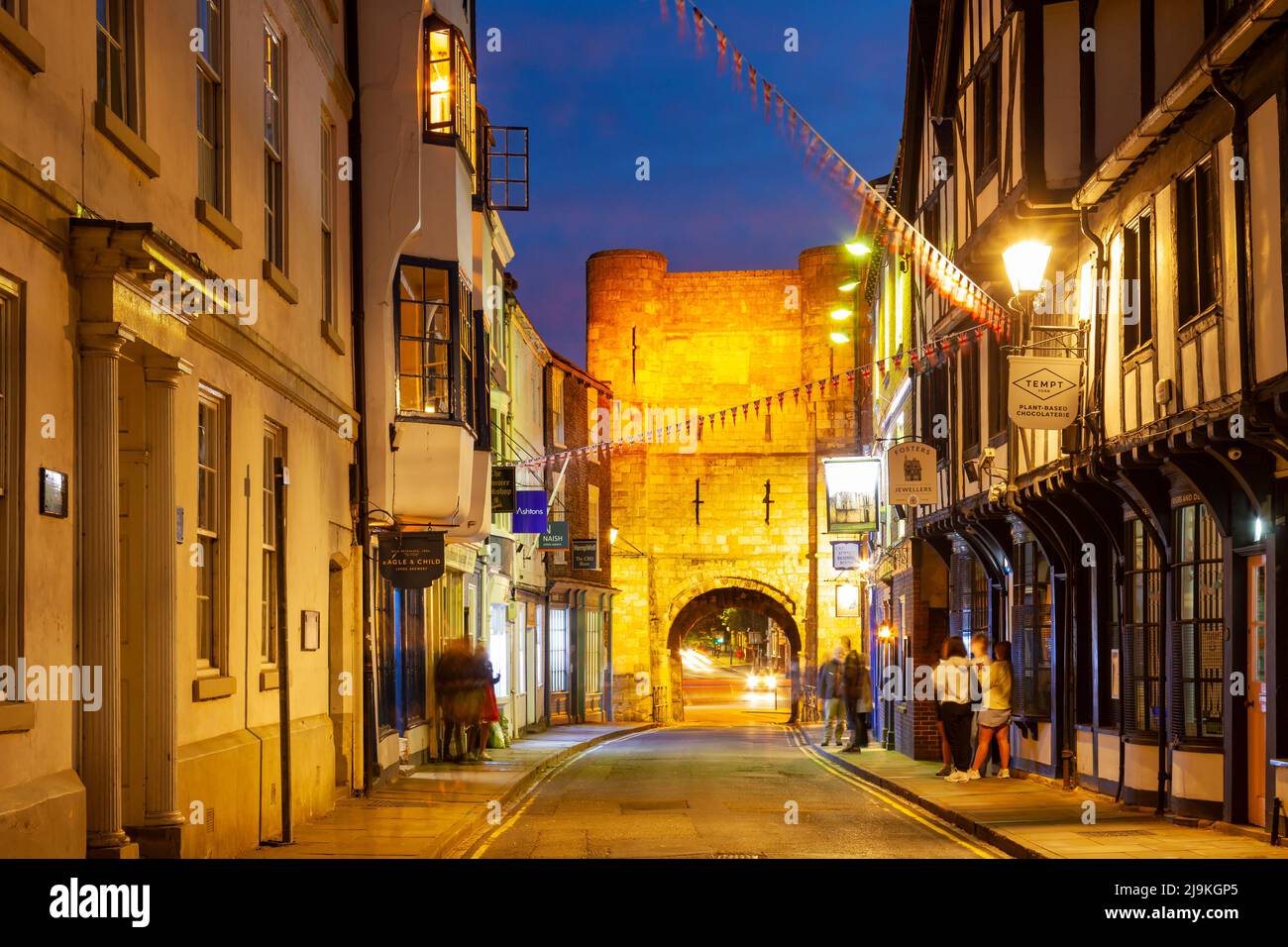 Die Nacht fällt auf High Petergate im Zentrum von York, Bootham Bar in der Ferne. North Yorkshire, England. Stockfoto