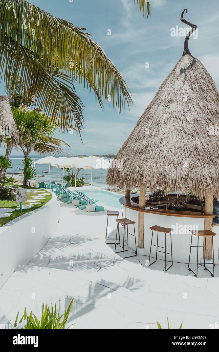 Tropische Barhütte auf der tropischen Insel Lembongan in Bali Indonesien an einem sonnigen Sommertag mit Sonnenschirmen und Palmen Stockfoto